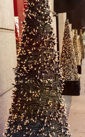 Row of artificial Christmas trees with fairy lightsの写真素材