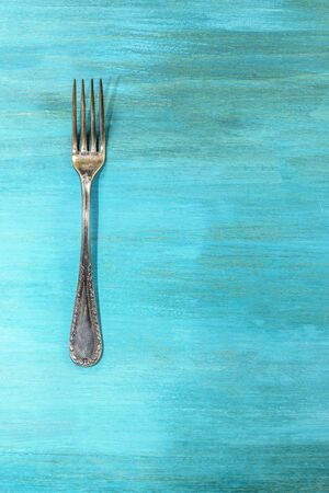 Vintage fork on vibrant turquoise with copyspaceの写真素材