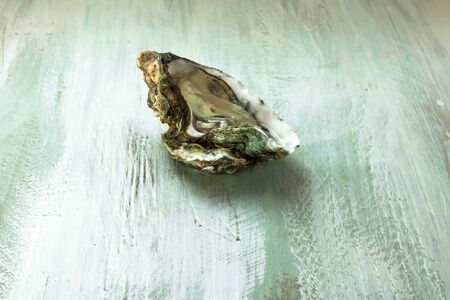 Freshly opened oyster on wooden background textureの写真素材