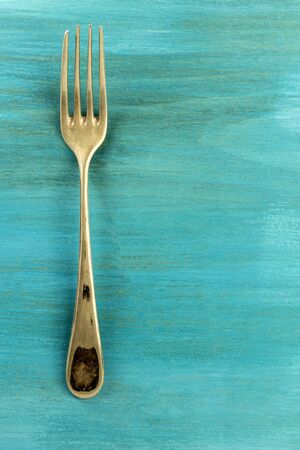Vintage fork on vibrant turquoise with copyspaceの写真素材