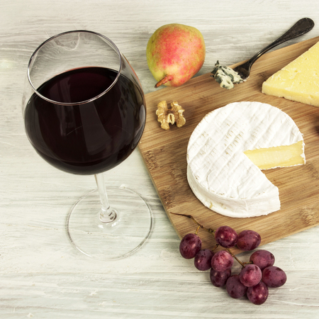 Red wine and selection of cheeses with grapesの写真素材