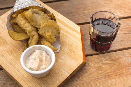 Fish and chips with tartar sauce, red wine glassの写真素材