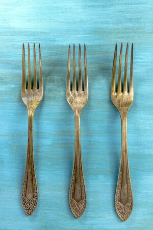 Vintage forks on vibrant turquoise with copyspaceの写真素材