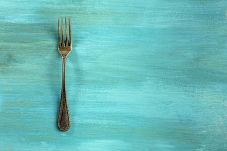 Vintage fork on vibrant turquoise with copyspaceの写真素材
