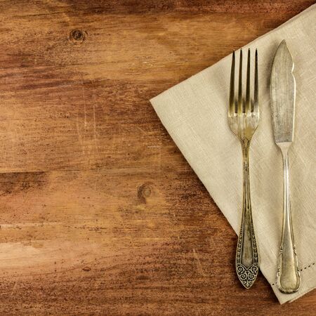 Vintage fork and knife on wooden backgroundの写真素材