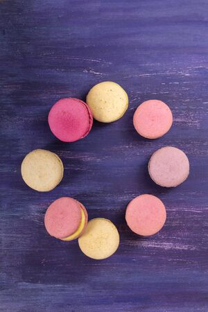 Macarons forming frame on vibrant purple textureの写真素材