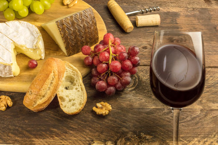 Wine and cheese tasting with bread, grapes and glassの写真素材