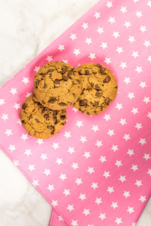 Chocolate chips cookies on a pink textile napkin