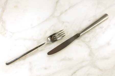 Retro fork and knife on white marble with copyspace