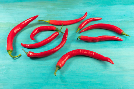 Red hot chili peppers on vibrant turquoise texture