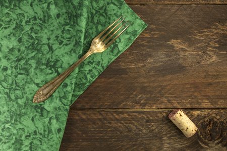 Vintage fork and wine cork on dark wooden backgroundの写真素材