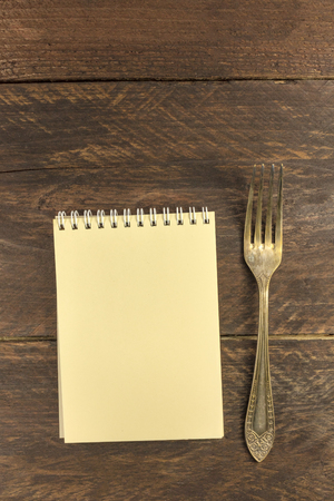 Vintage fork and notepad for copyspace, overhead shotの写真素材