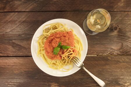 Plate of spaghetti with tomato sauce and white wineの写真素材