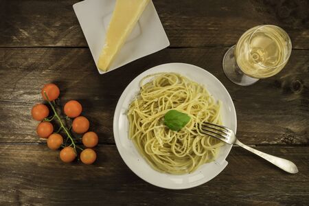 Plate of spaghetti with white wine, cheese, and cherry tomatoesの写真素材