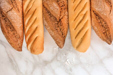 Rye and wheat bread with flour on white marbleの写真素材
