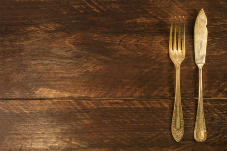 Vintage fork and knife on wooden backgroundの写真素材