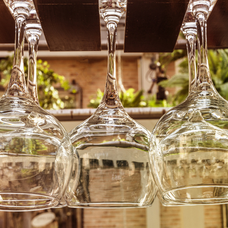 Wine glasses hanging on rack on restaurant terraceの写真素材