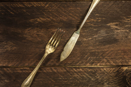 Vintage fork and knife on wooden background