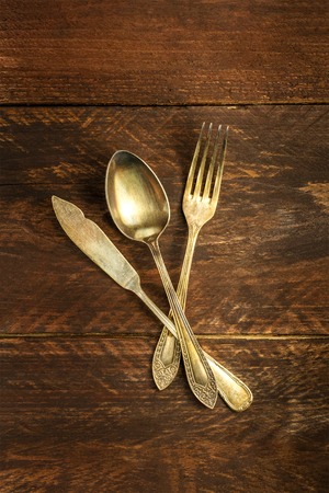 Vintage fork and knife on wooden backgroundの写真素材