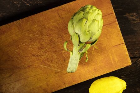 Artichoke and lemon on dark rustic textures with copyspaceの写真素材