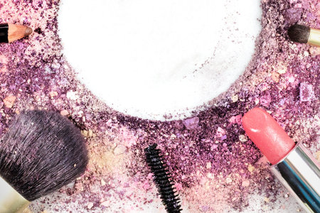Makeup brushes, lipstick, and pencil with powder and copyspace