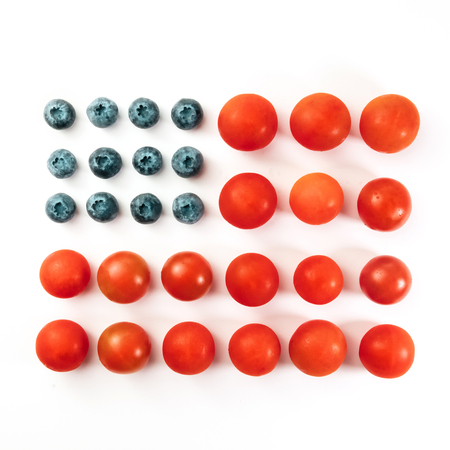 American flag of blueberries and cherry tomatoes on whiteの写真素材