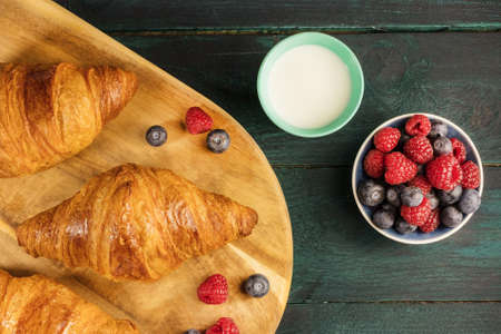 Crunchy French croissants with fresh berries and milkの写真素材