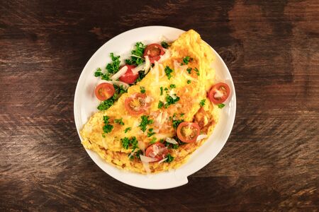 Omelette with parsley, cherry tomatoes, and copyspaceの写真素材