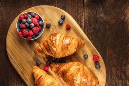 Crunchy French croissants with fresh raspberries and blueberriesの写真素材