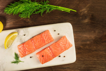 Two slices of salmon on dark background with copyspaceの写真素材