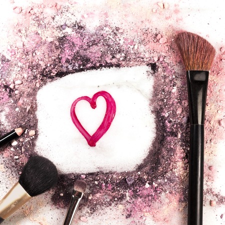 Heart drawn with lipgloss, and makeup brushesの写真素材