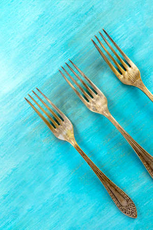 Vintage forks on vibrant turquoise with copyspaceの写真素材