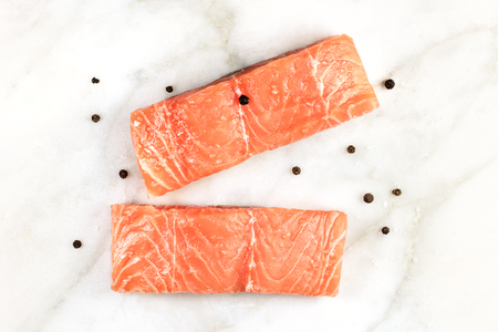 Slices of salmon on white marble table with copyspaceの写真素材