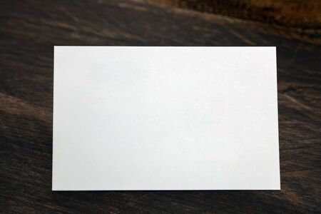Blank white business card on dark rustic backgroundの写真素材