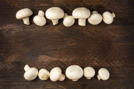 Overhead photo of white mushrooms on rustic texture with copyspaの写真素材