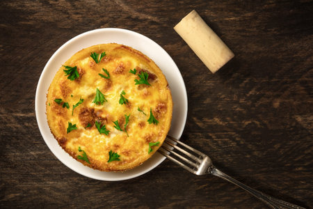 Overhead photo of French quiche on rustic texture with cork