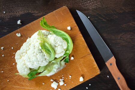 Overhead photo of cauliflower on used cutting boardの写真素材