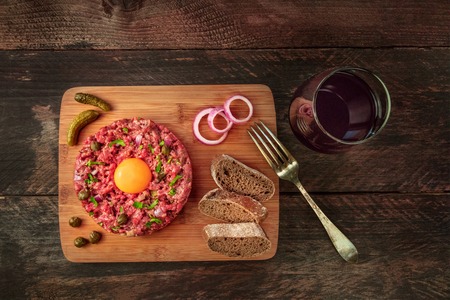 Steak tartare with garnish, red wine, and copyspaceの写真素材