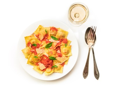 Plate of ravioli with tomato sauce and wine on whiteの写真素材