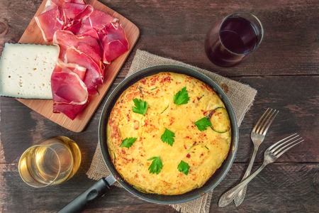 Spanish tortilla in tortillera, with wine, jamon, and cheeseの写真素材