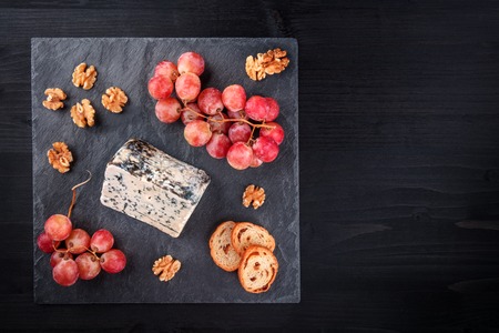 Blue cheese and grapes on black with copy spaceの写真素材