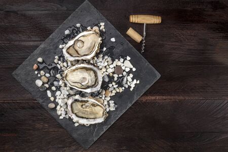 Overhead photo of oysters with wine cork and corkscrew and copy spaceの写真素材