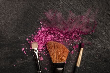 Closeup of makeup brushes with eye shadow on black with copy spaceの写真素材