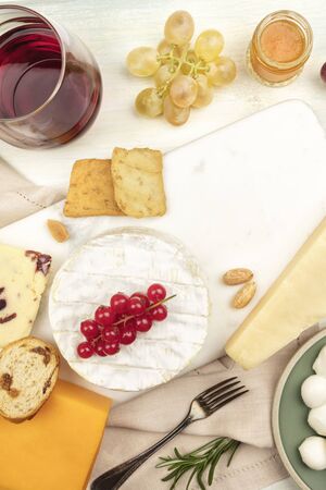 Various types of cheese with wine on a light backgroundの写真素材
