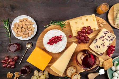 Various types of cheese with wine on a rustic backgroundの写真素材