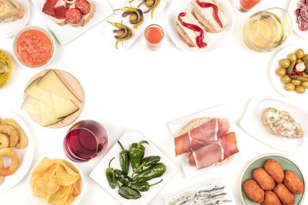 An overhead photo of Spanish tapas, forming frame on white with place for textの写真素材