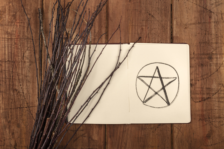 An overhead photo of an open grimoire with a broom and copy spaceの写真素材