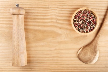 An overhead photo of a mix of various peppers with a pepper mill and a wooden ladle, with copy spaceの写真素材