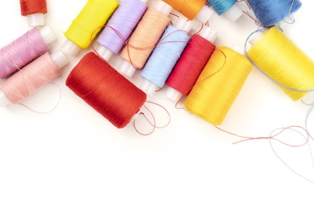 Overhead photo of threads of various colors on white with copy spaceの写真素材