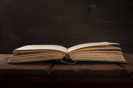 An open old book on a dark background with copy spaceの写真素材